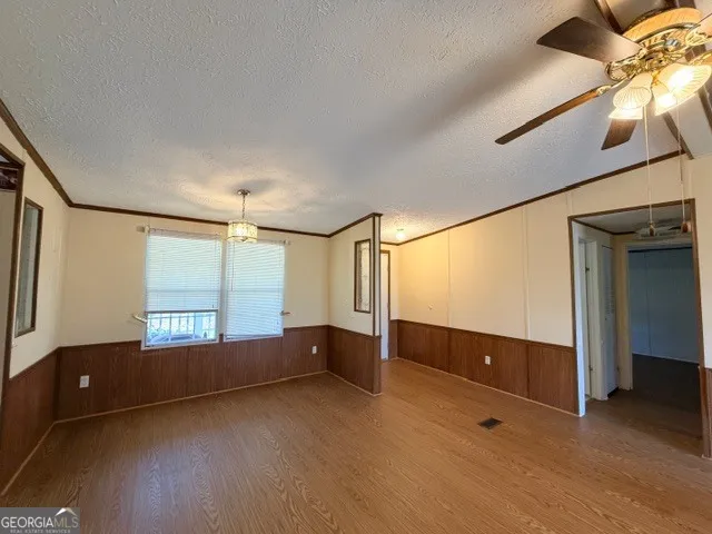 a view of an empty room with a chandelier fan