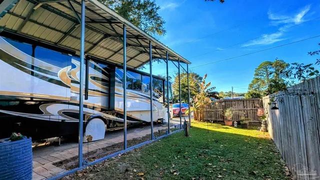 a backyard of a house with table and chairs plants and large tree