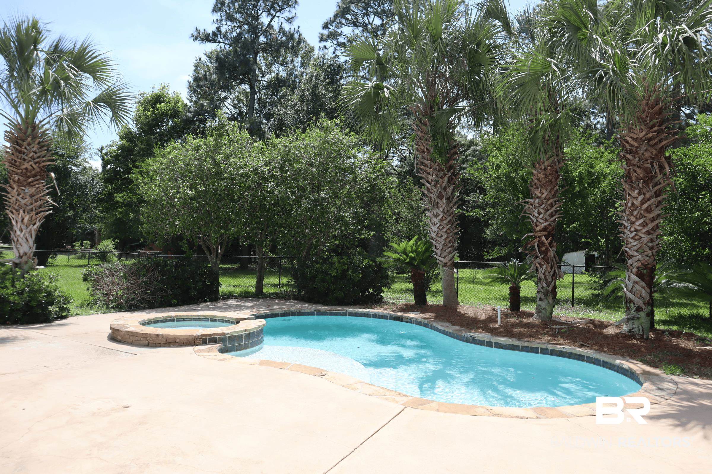 12150 Lee Bishop Road Irvington, AL 36544 - Photo 5 of 26 View of swimming pool featuring a patio area, fence, and a pool with connected hot tub