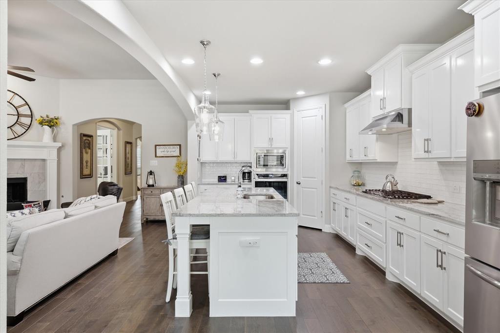 9708 Surveyor Road Oak Point, TX 75068 - Photo 4 of 34 Gourmet kitchen with white cabinetry, stainless steel appliances, and a central island featuring pendant lighting