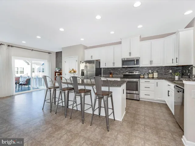a kitchen with appliances a sink a counter top space and cabinets