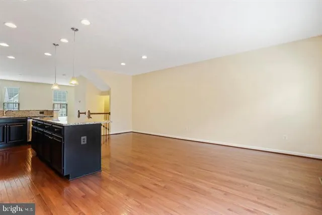 a open kitchen with a sink and wooden floor