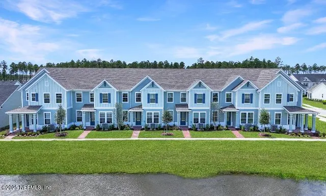 a view of a big house with a big yard and large trees