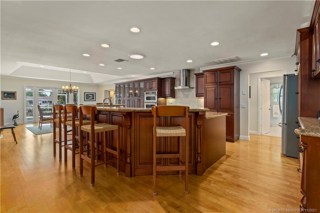 1996 Northwest Fork Road Stuart, FL 34994 - Photo 12 of 59 a open kitchen with stainless steel appliances granite countertop a table and chairs