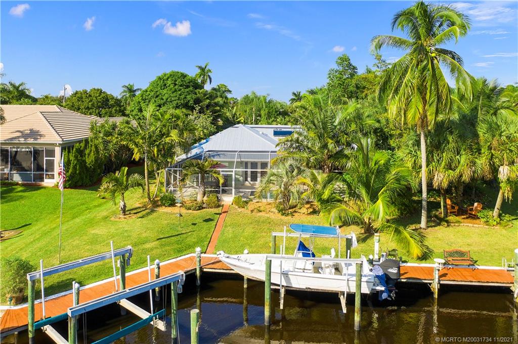 1996 Northwest Fork Road Stuart, FL 34994 - Photo 2 of 59 a view of a swimming pool with a lawn chairs under an umbrella