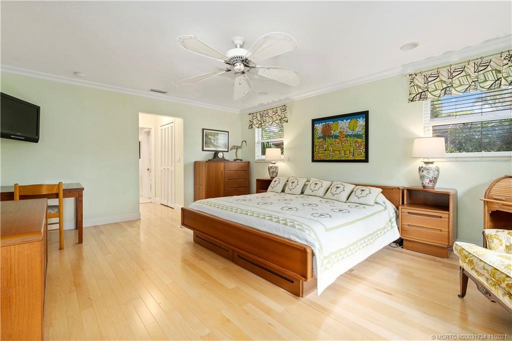 1996 Northwest Fork Road Stuart, FL 34994 - Photo 27 of 59 a spacious bedroom with a bed a couch and a window