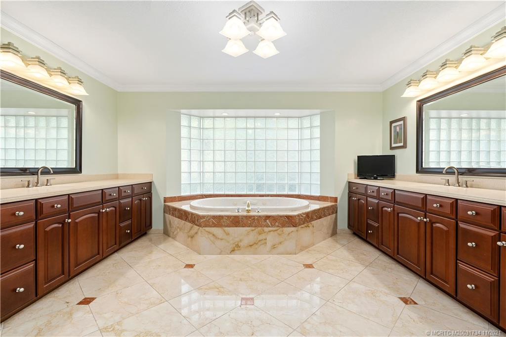 1996 Northwest Fork Road Stuart, FL 34994 - Photo 31 of 59 a spacious bathroom with a double vanity sink large mirror and a bathtub