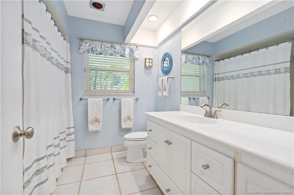 1996 Northwest Fork Road Stuart, FL 34994 - Photo 37 of 59 a bathroom with a sink a toilet and a large mirror