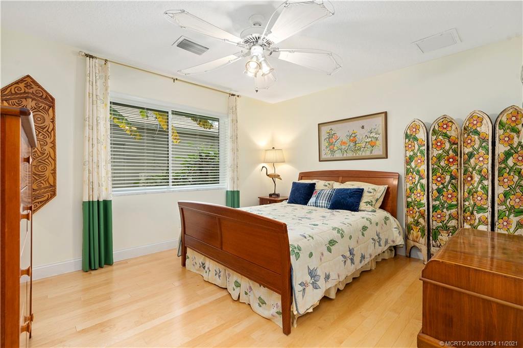 1996 Northwest Fork Road Stuart, FL 34994 - Photo 38 of 59 a bedroom with a bed and a chandelier
