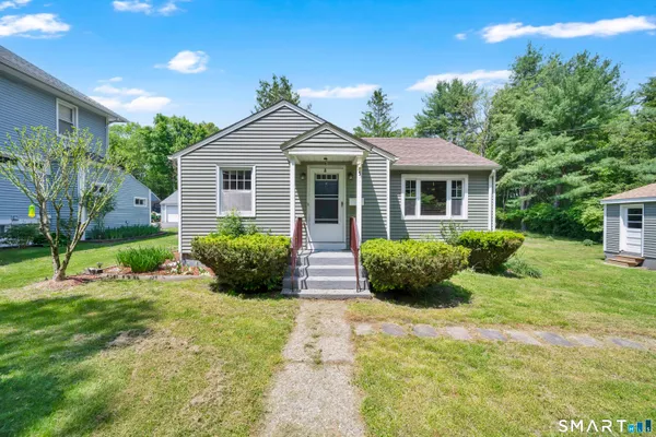 a view of a house with a yard and potted plants