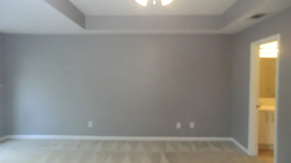 an empty room with closet and a ceiling fan