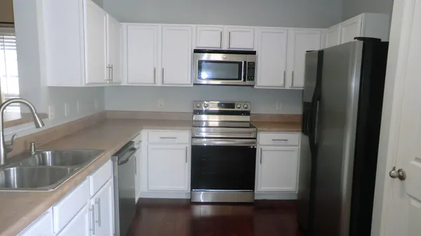 a kitchen with stainless steel appliances granite countertop a refrigerator stove and sink