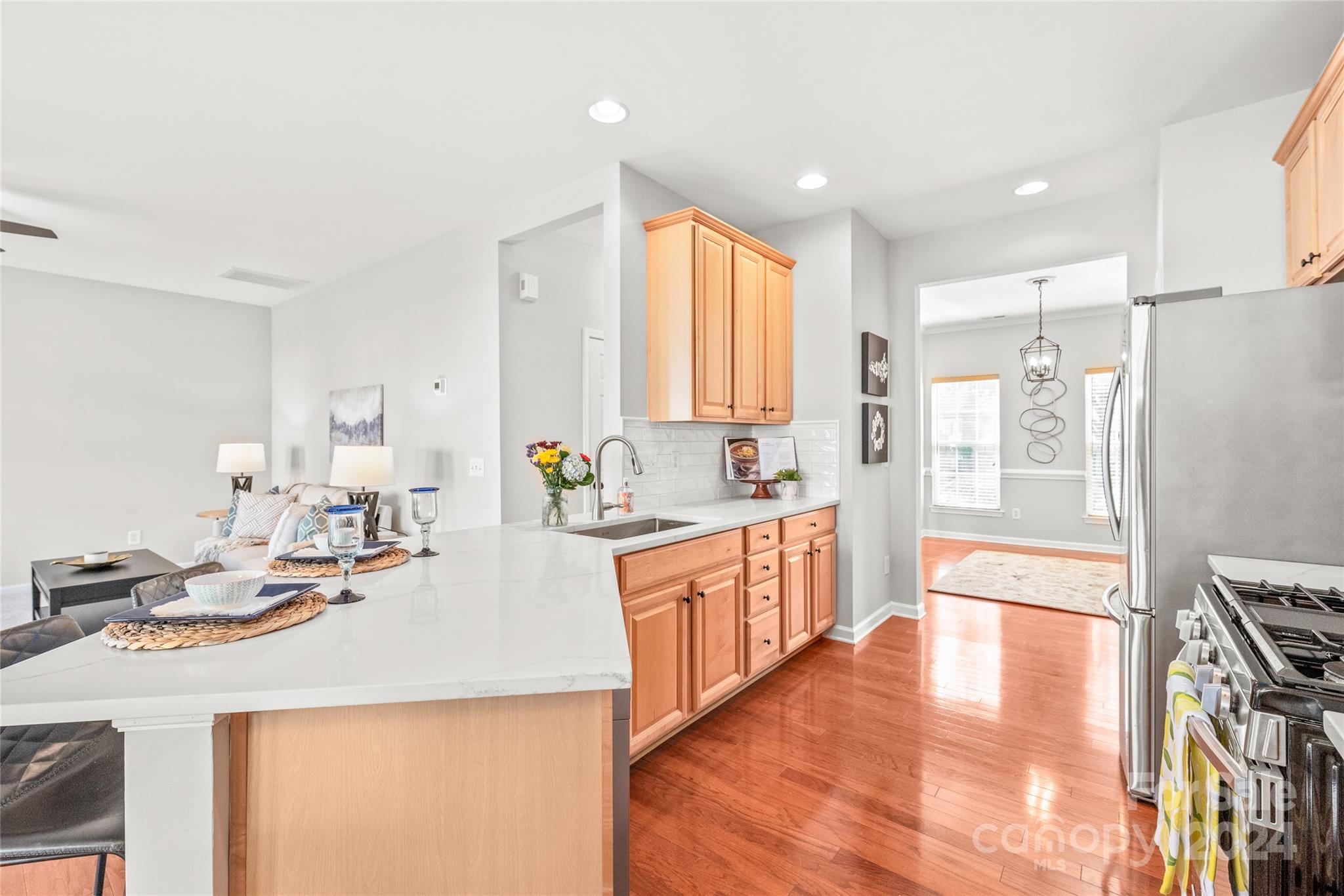 205 Snead Road Fort Mill, SC 29715 - Photo 7 of 33 a kitchen with stainless steel appliances kitchen island granite countertop a refrigerator a stove and white cabinets with wooden floor