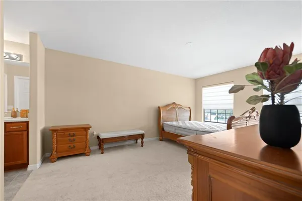 a bedroom with a bed and a potted plant