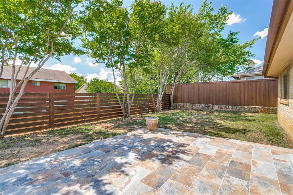 200 Lark Lane Euless, TX 76039 - Photo 24 of 25 a view of a backyard with large trees and wooden fence