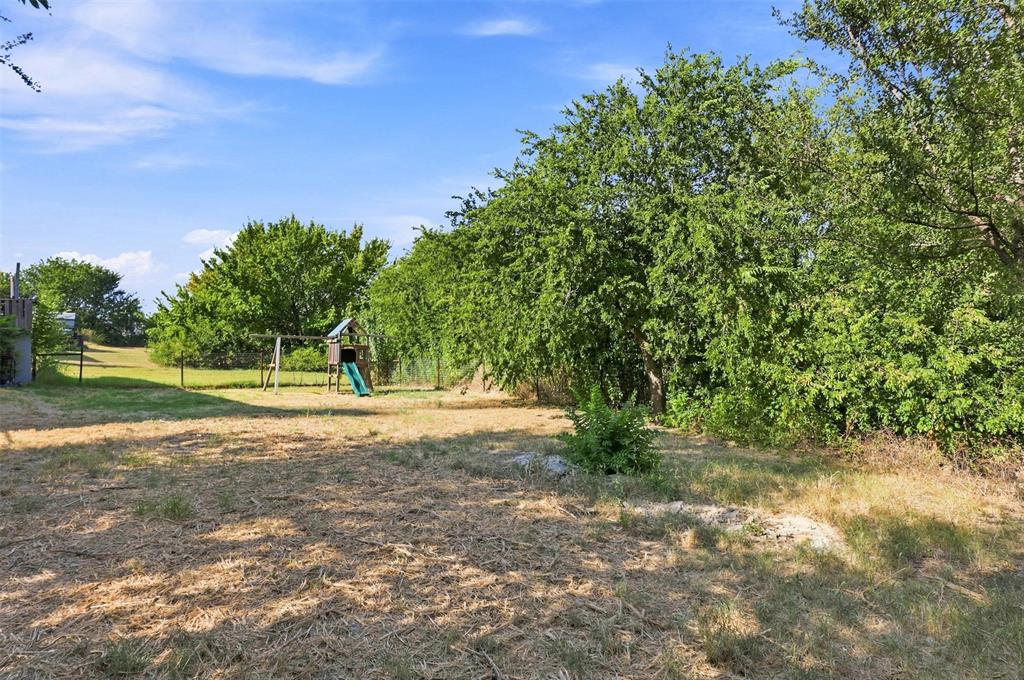 5519 Upper Denton Road Weatherford, TX 76085 - Photo 24 of 38 Expansive exterior grounds with mature trees and a partial fence line