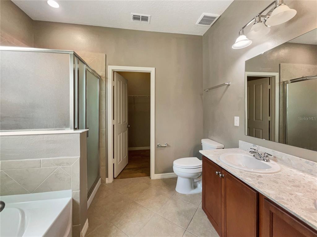 10017 Weathers Loop Clermont, FL 34711 - Photo 13 of 23 a bathroom with a granite countertop sink toilet and shower