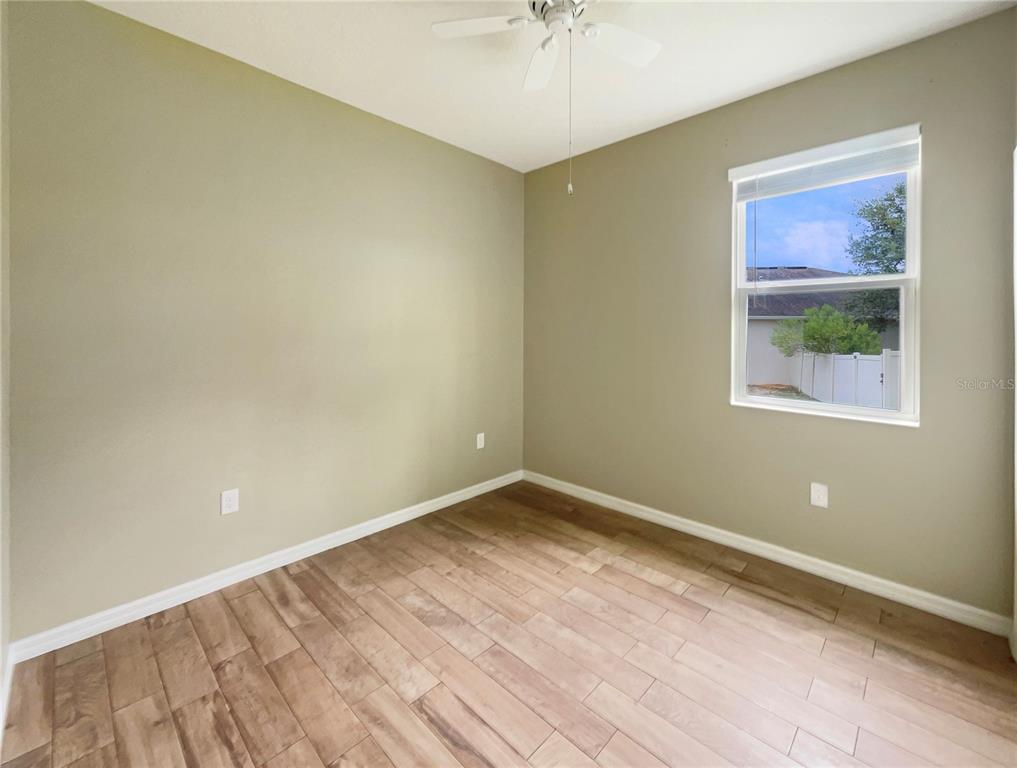 10017 Weathers Loop Clermont, FL 34711 - Photo 14 of 23 wooden floor in an empty room with a window
