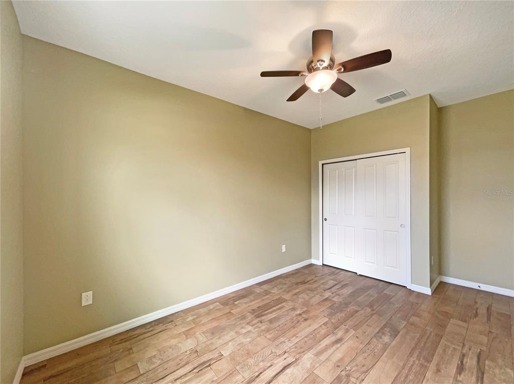 10017 Weathers Loop Clermont, FL 34711 - Photo 15 of 23 an empty room with wooden floor and ceiling fan
