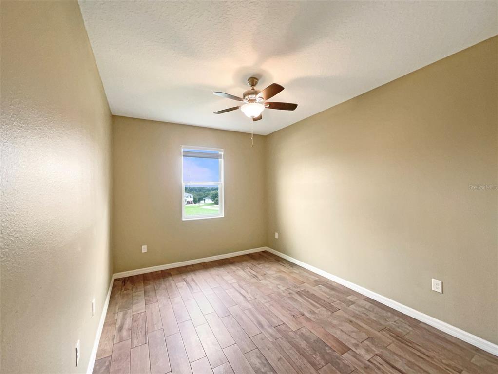 10017 Weathers Loop Clermont, FL 34711 - Photo 16 of 23 wooden floor in an empty room with a window