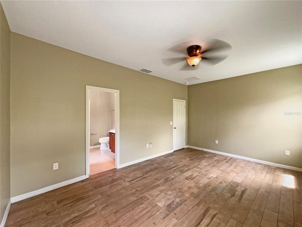 10017 Weathers Loop Clermont, FL 34711 - Photo 19 of 23 wooden floor in an empty room with a window