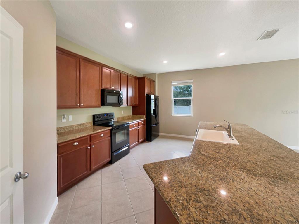 10017 Weathers Loop Clermont, FL 34711 - Photo 5 of 23 a large kitchen with granite countertop a large counter top stainless steel appliances and cabinets