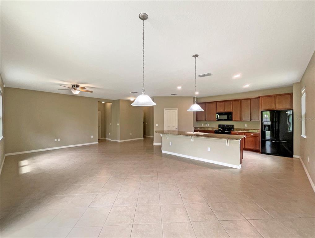 10017 Weathers Loop Clermont, FL 34711 - Photo 7 of 23 a view of a kitchen with kitchen island a counter top space a sink and a ceiling fan
