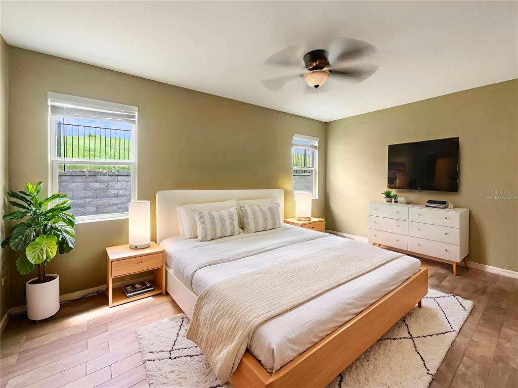 10017 Weathers Loop Clermont, FL 34711 - Photo 9 of 23 a bedroom with a bed and a flat screen tv