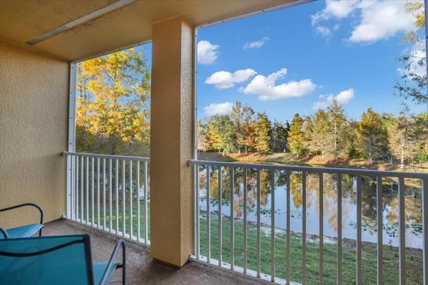 a view of a balcony with wooden floor & fence