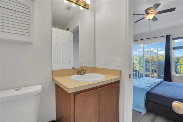 a en suite bathroom with a granite countertop sink and a mirror