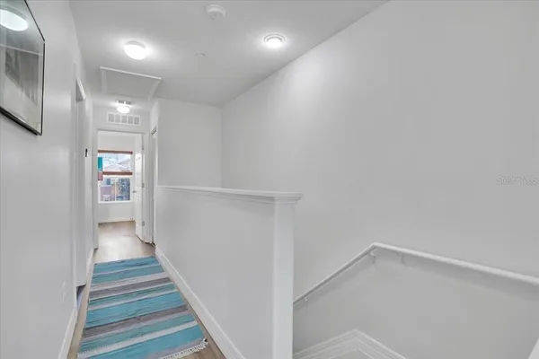 a view of a hallway with wooden floor and staircase