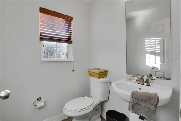 a bathroom with a toilet a sink and mirror