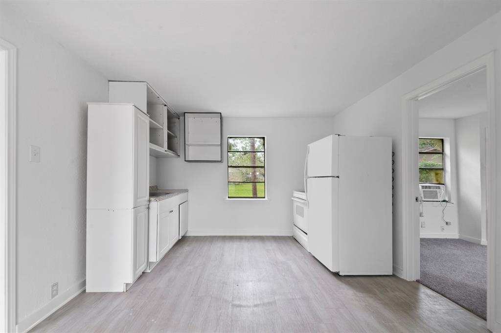a kitchen with white cabinets and white appliances