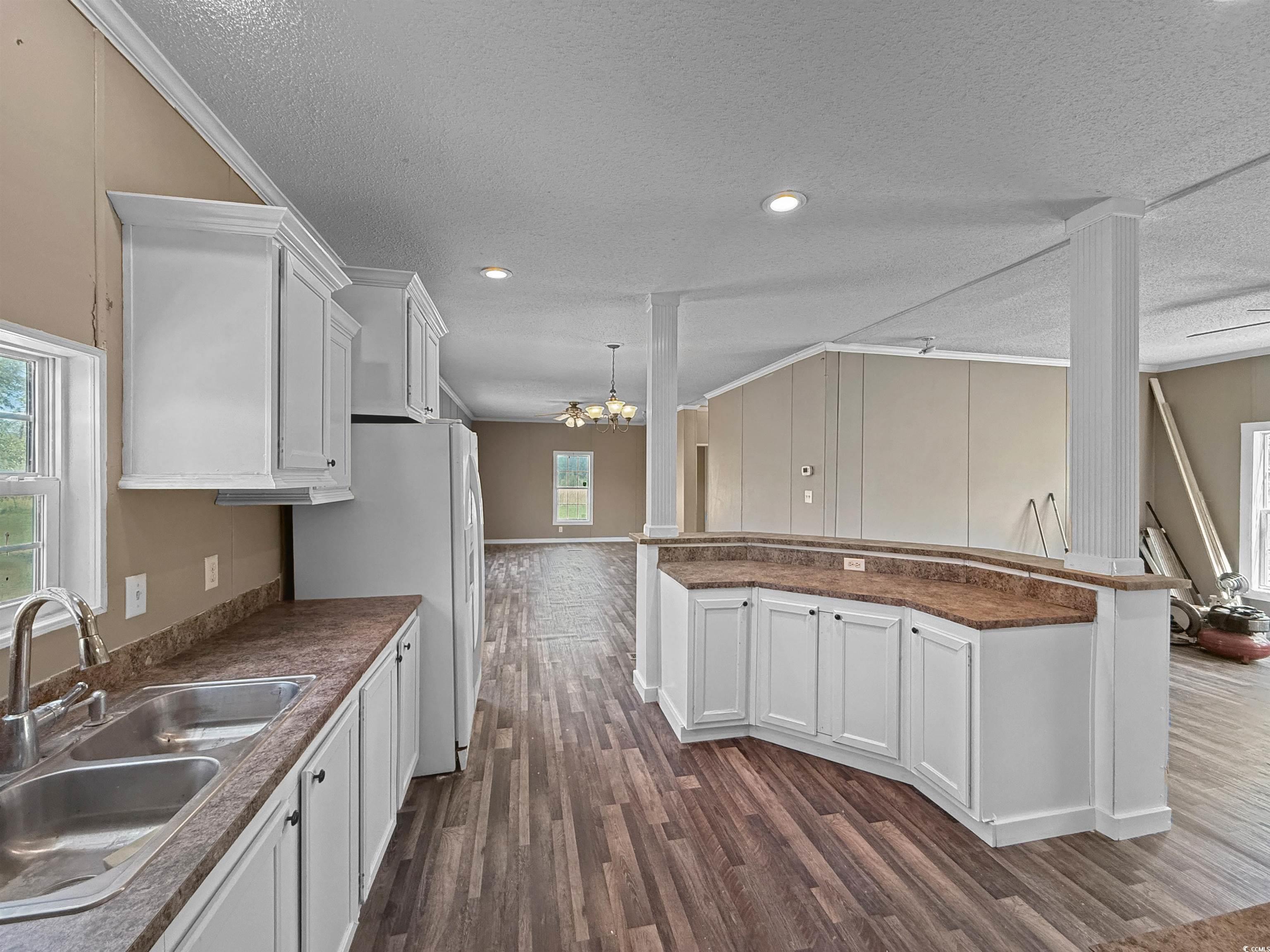111 Morrisville Road Andrews, SC 29510 - Photo 12 of 28 Kitchen featuring a sink, a textured ceiling, an inviting chandelier, and dark wood-style flooring