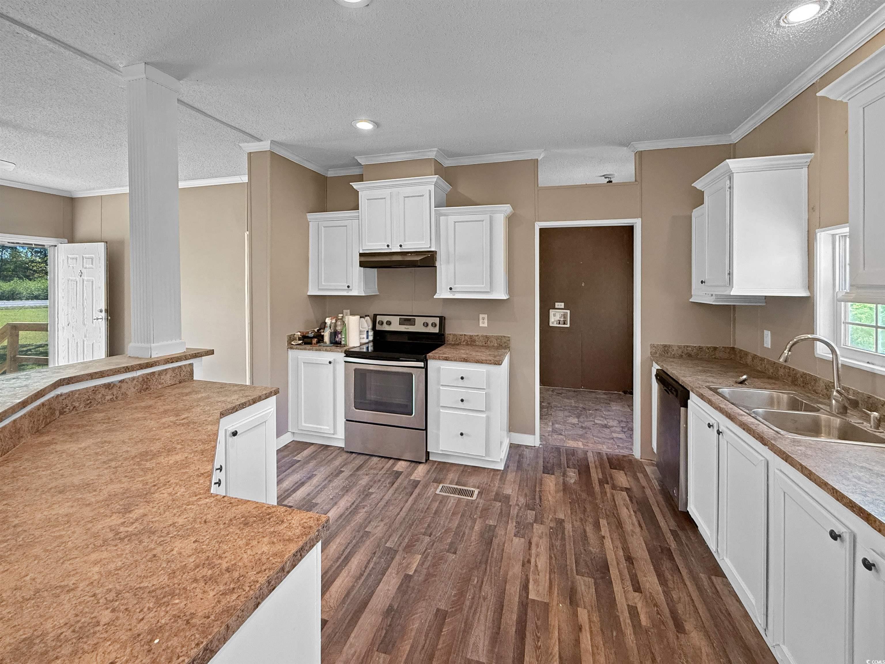 111 Morrisville Road Andrews, SC 29510 - Photo 13 of 28 Kitchen with white cabinets, a sink, appliances with stainless steel finishes, a textured ceiling, and dark wood-type flooring