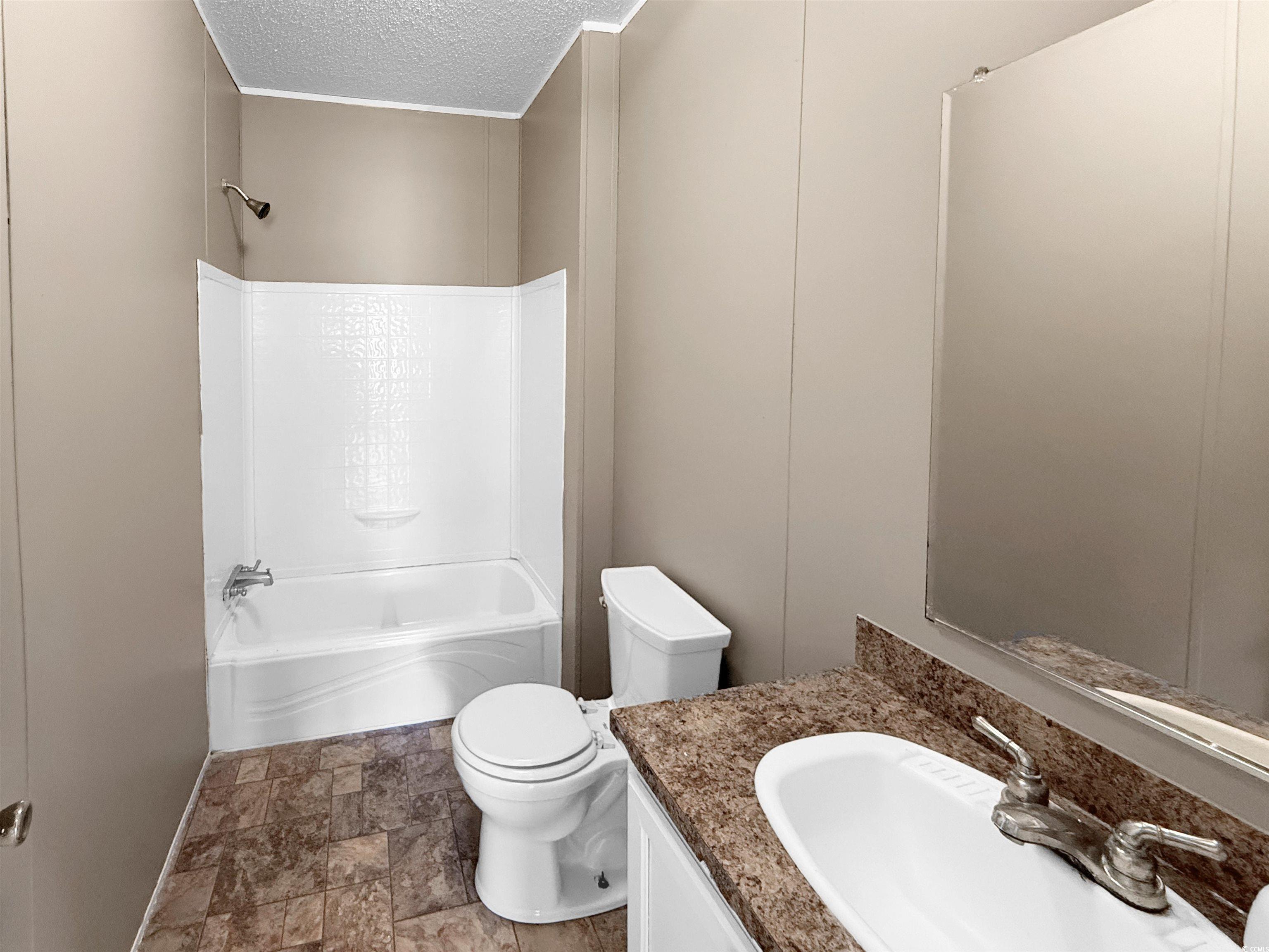 111 Morrisville Road Andrews, SC 29510 - Photo 21 of 28 Bathroom featuring vanity, a textured ceiling, toilet, shower / bathing tub combination, and stone finish flooring