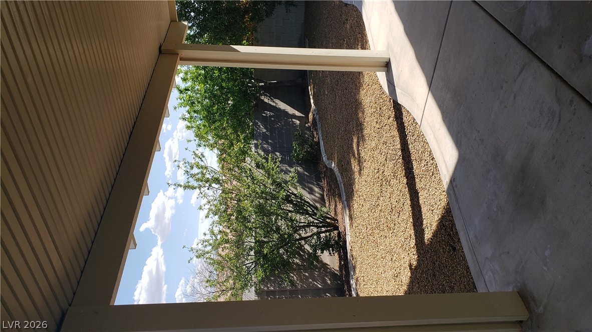 9112 Manalang Road Las Vegas, NV 89123 - Photo 9 of 50 A well-maintained concrete patio extends to a xeriscaped yard with vibrant greenery and a sturdy block wall.