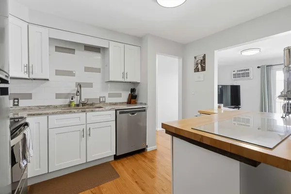 a kitchen with granite countertop white cabinets and white appliances