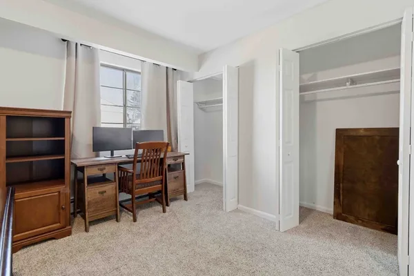 a view of a workspace with furniture and a window