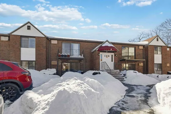 a bed sitting in a bedroom next to a larger window