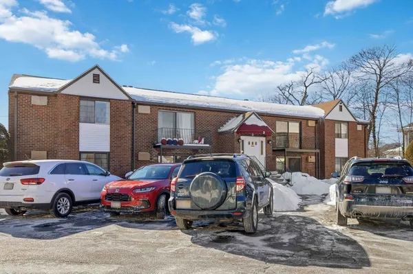 a view of a house with cars parked