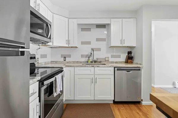 a kitchen with stainless steel appliances granite countertop a stove a sink and a microwave