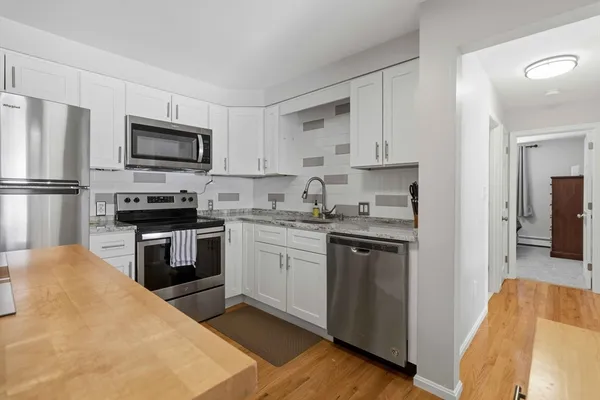 a kitchen with kitchen island a refrigerator stove top oven and sink