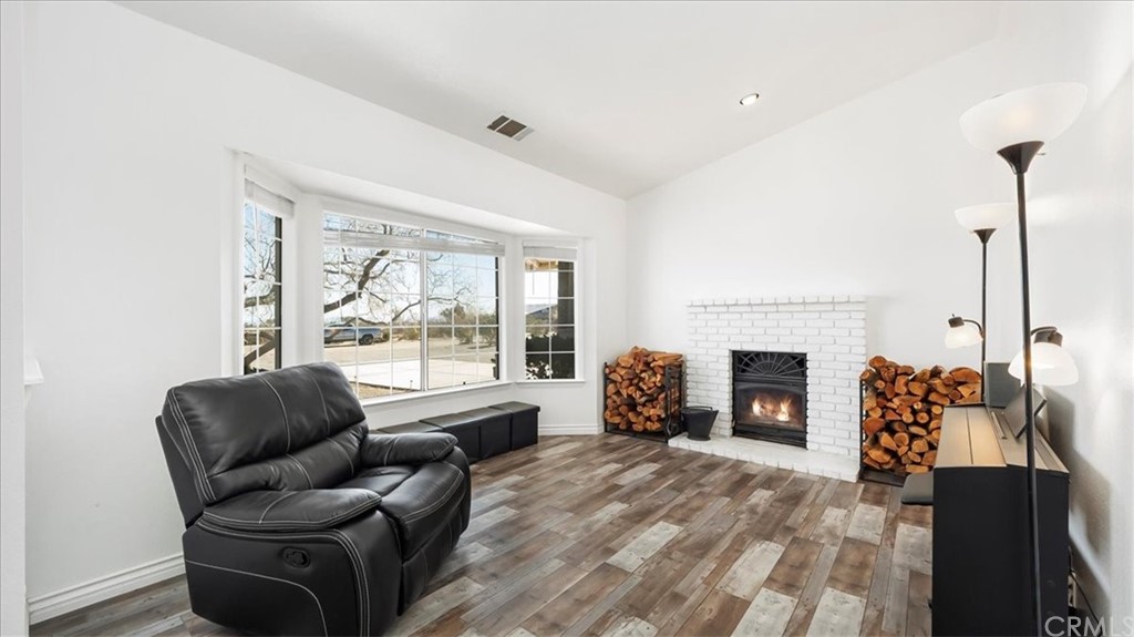 a living room with furniture a fireplace and a floor to ceiling window