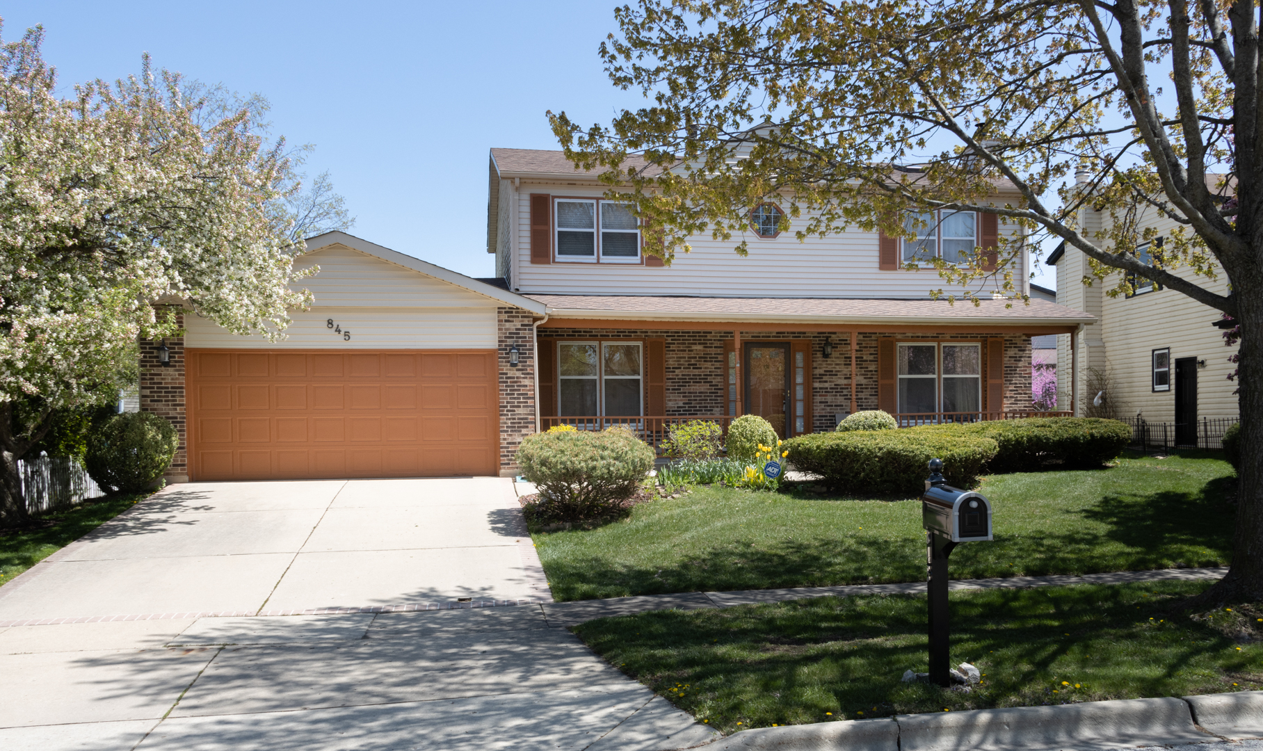 a front view of a house with yard and green space