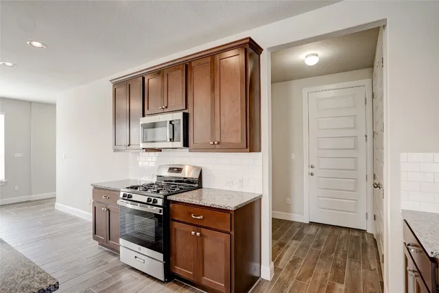 a kitchen with stainless steel appliances granite countertop a stove and a microwave