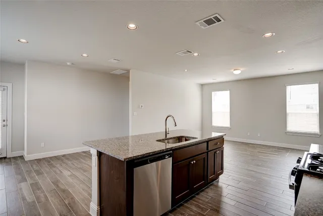 a kitchen with a sink and wooden floor