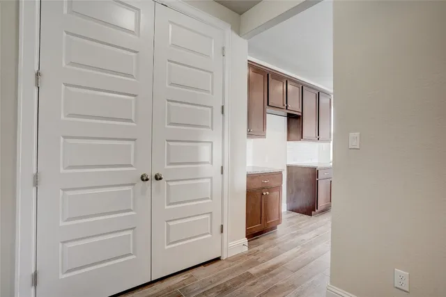 a view of kitchen with stainless steel appliances wooden floor and window