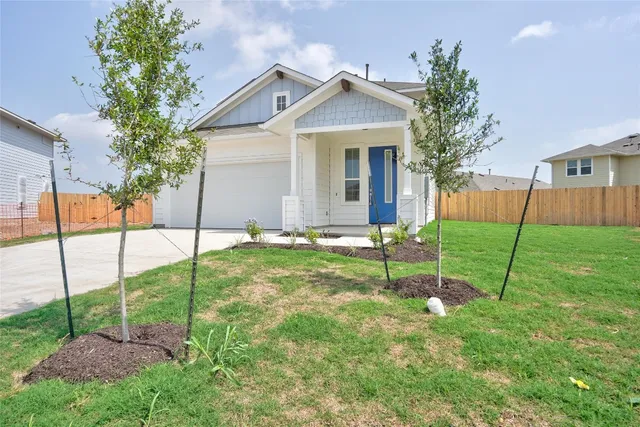 a view of a house with backyard and a garden