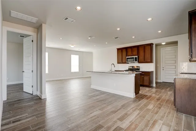 a view of kitchen with microwave refrigerator and cabinets